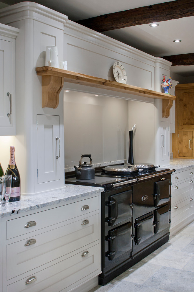 Expansive country kitchen in Other with an undermount sink, shaker cabinets, white cabinets, granite benchtops, white splashback, glass sheet splashback, black appliances and with island.