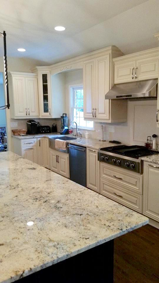 Inspiration for a large transitional l-shaped dark wood floor and brown floor eat-in kitchen remodel in Miami with a farmhouse sink, raised-panel cabinets, white cabinets, gray backsplash, subway tile backsplash, stainless steel appliances and an island