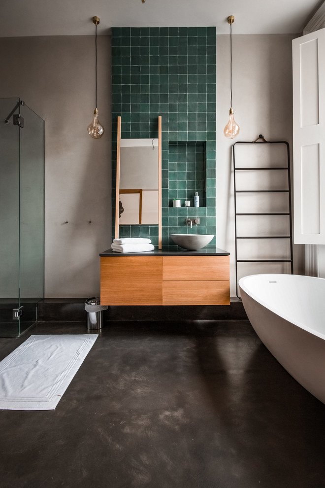 Design ideas for a large contemporary 3/4 bathroom in London with a freestanding tub, terra-cotta tile, beige walls, wood benchtops, flat-panel cabinets, concrete floors, a vessel sink, grey floor, a hinged shower door, medium wood cabinets and green tile.