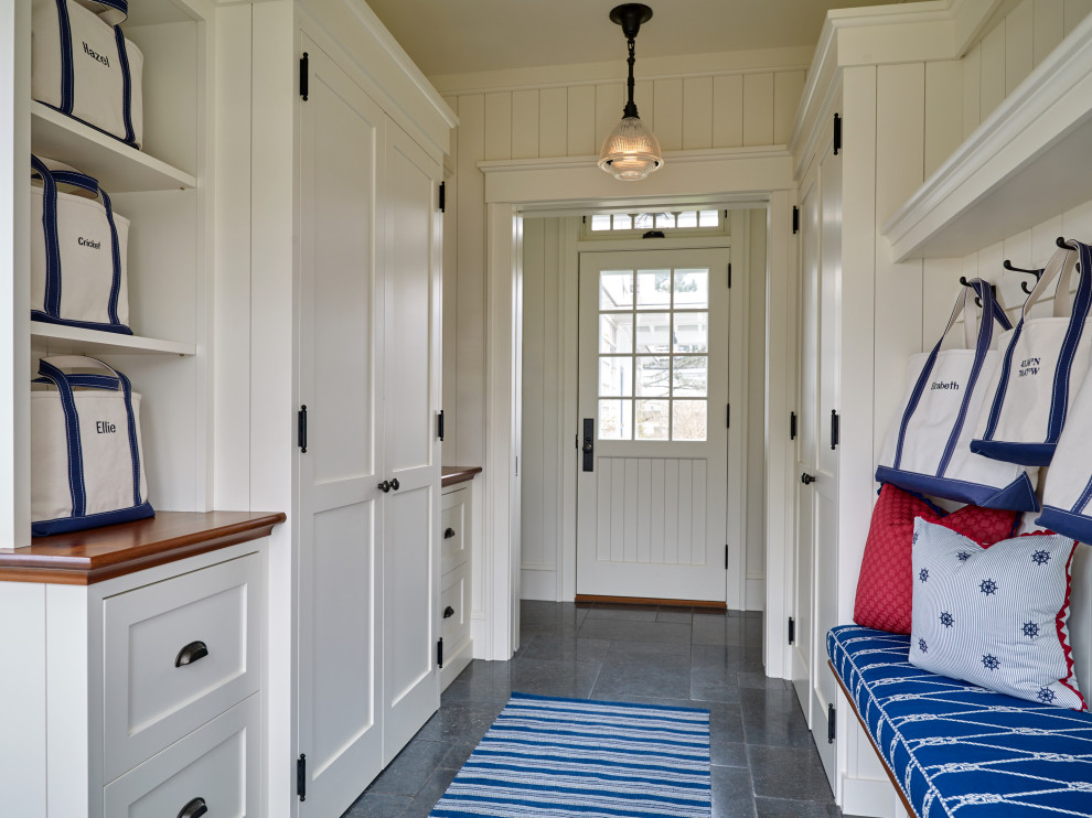 Photo of a beach style entryway in Portland Maine with planked wall panelling.