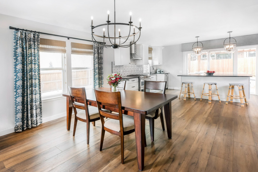 Farmhouse dining room in Denver with vinyl flooring and brown floors.