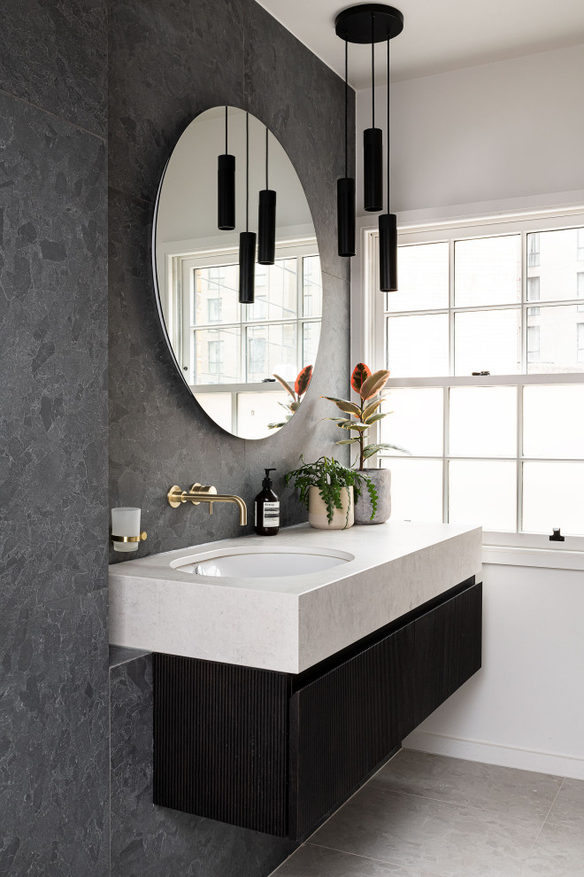 Inspiration for a contemporary bathroom in London with flat-panel cabinets, black cabinets, grey tiles, grey walls, a submerged sink, grey floors, white worktops, a single sink and a floating vanity unit.