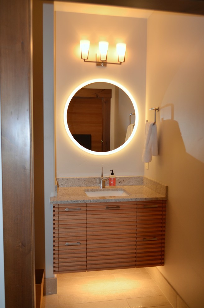 Photo of a mid-sized industrial kids bathroom in Seattle with furniture-like cabinets, brown cabinets, an alcove shower, an urinal, multi-coloured tile, porcelain tile, brown walls, porcelain floors, an undermount sink, granite benchtops, beige floor and a hinged shower door.