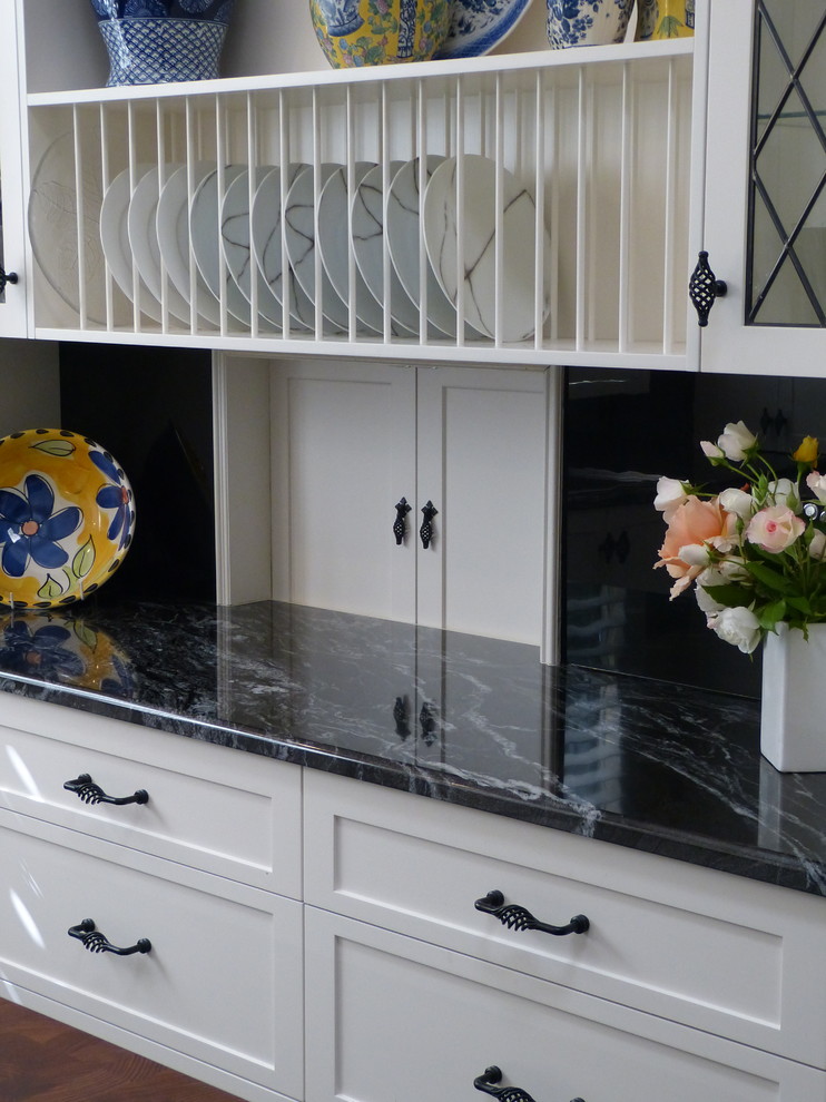 Photo of a mid-sized traditional u-shaped separate kitchen in Adelaide with a double-bowl sink, shaker cabinets, white cabinets, granite benchtops, black splashback, glass tile splashback, white appliances, slate floors, with island, black floor and black benchtop.