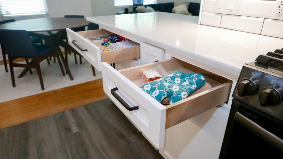 Mid-sized transitional galley porcelain tile and gray floor eat-in kitchen photo with an undermount sink, shaker cabinets, white cabinets, quartz countertops, white backsplash, subway tile backsplash, black appliances, no island and white countertops