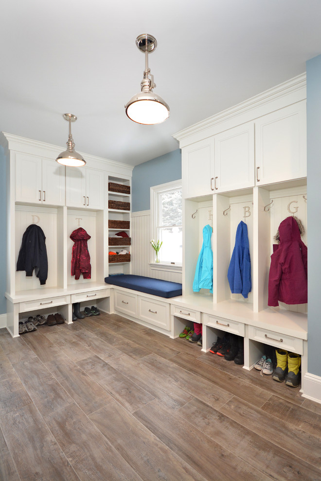 Photo of a mid-sized transitional entryway in New York with blue walls and medium hardwood floors.