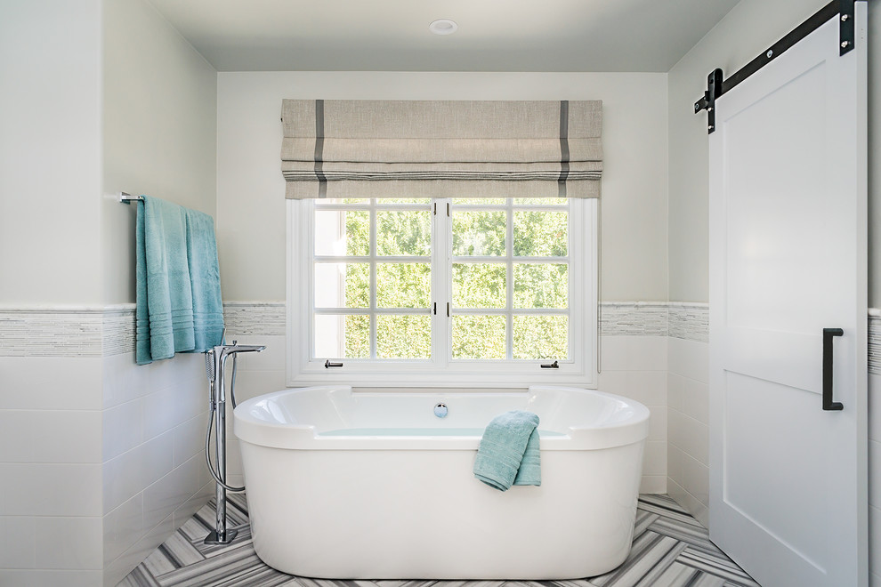 Large transitional master black and white tile and matchstick tile marble floor freestanding bathtub photo in Los Angeles with shaker cabinets, white cabinets, gray walls, an undermount sink and quartz countertops