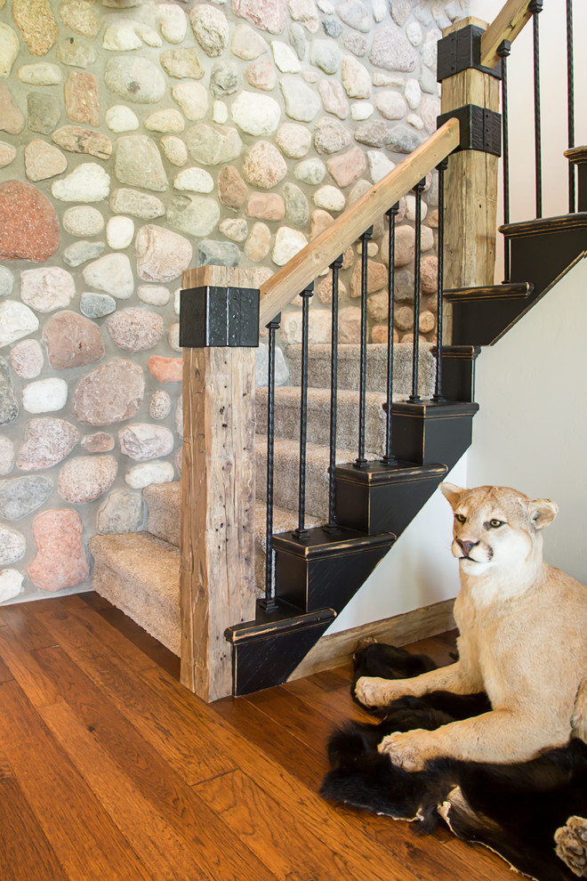 Example of a large mountain style carpeted curved staircase design with carpeted risers