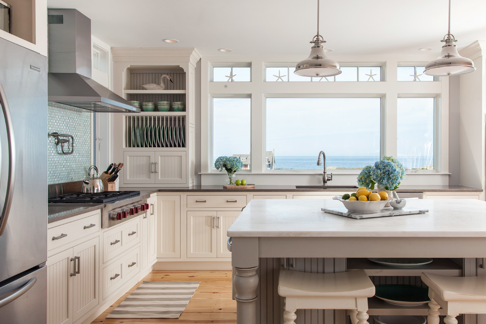 Inspiration for a mid-sized beach style l-shaped separate kitchen in Boston with an undermount sink, beaded inset cabinets, mosaic tile splashback, stainless steel appliances, light hardwood floors, with island, white cabinets and blue splashback.