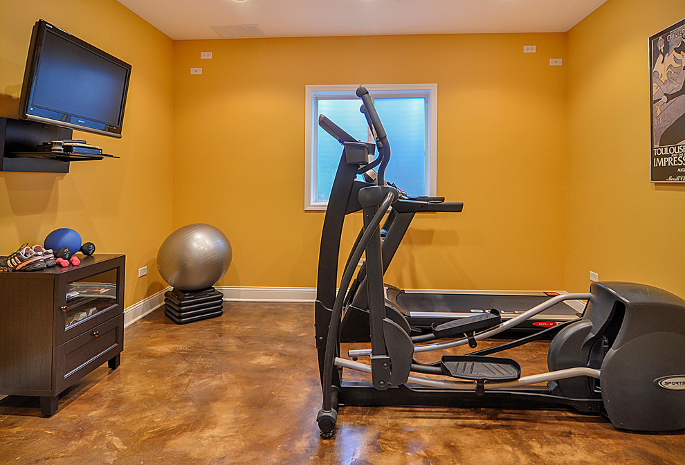 This is an example of a large traditional home gym in Nashville with yellow walls and concrete floors.