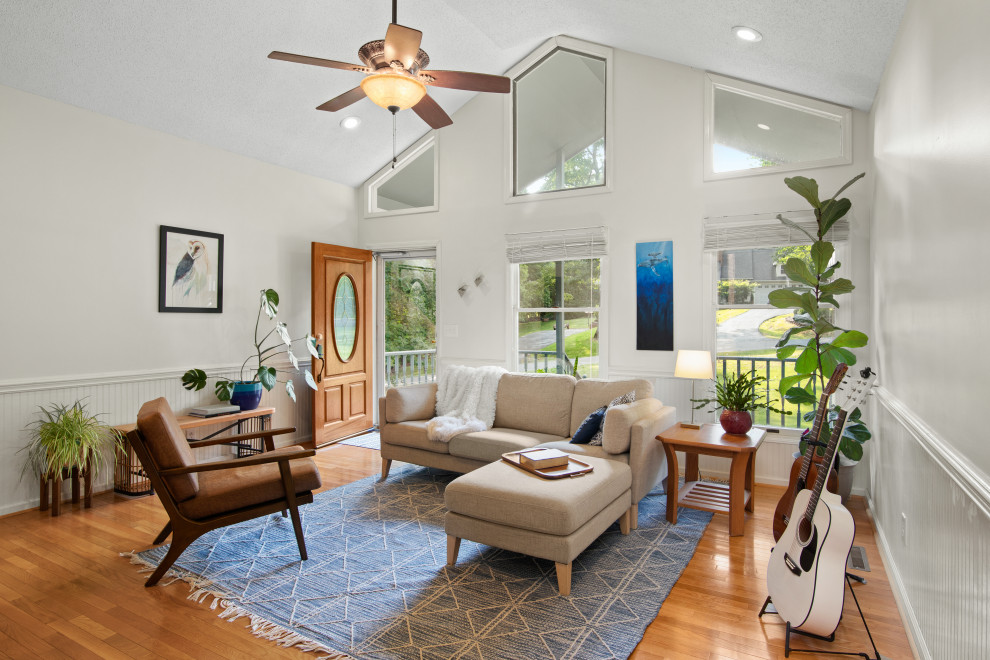 Inspiration for a mid-sized transitional light wood floor and brown floor living room remodel with a music area and white walls