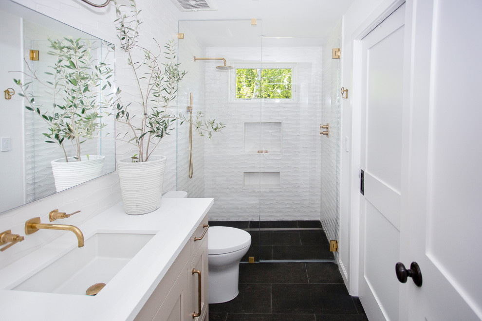 Idée de décoration pour une salle de bain de taille moyenne avec un placard à porte affleurante, une baignoire indépendante, WC à poser, un carrelage blanc, des carreaux de céramique, un mur blanc, un sol noir, une cabine de douche à porte battante, un plan de toilette blanc, meuble simple vasque et meuble-lavabo encastré.