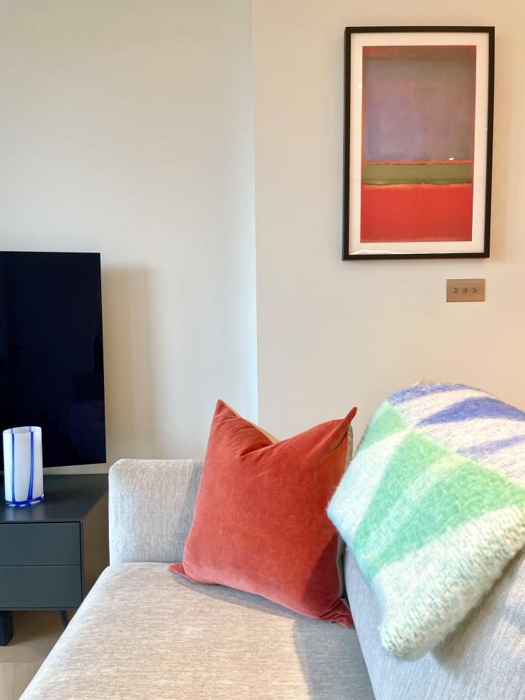 Immagine di un soggiorno contemporaneo di medie dimensioni e aperto con pareti bianche, parquet chiaro, TV autoportante e pavimento grigio