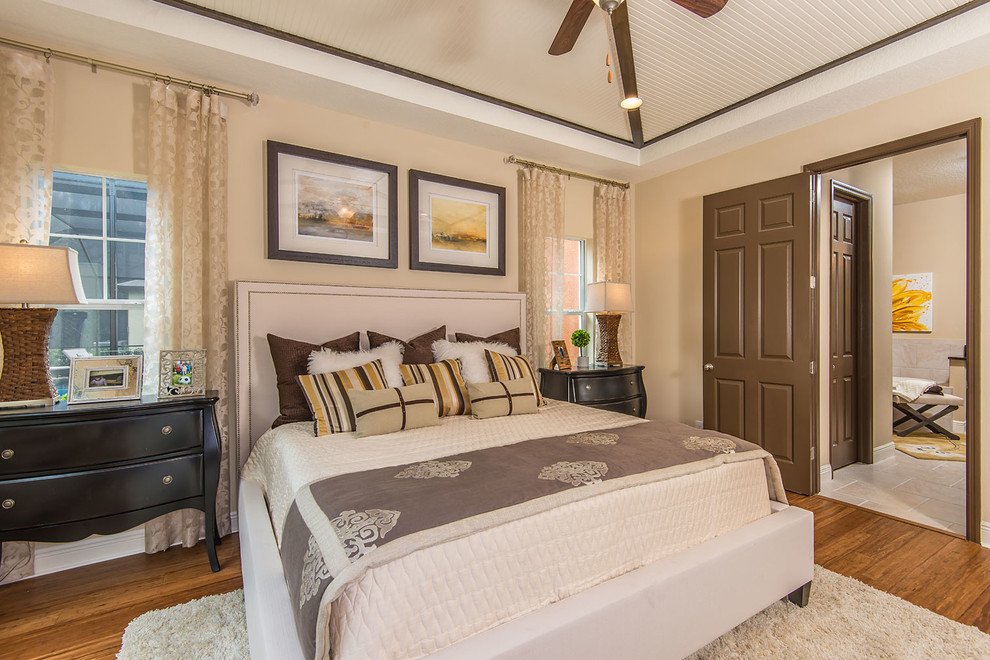 This is an example of a transitional bedroom in Tampa with beige walls and medium hardwood floors.