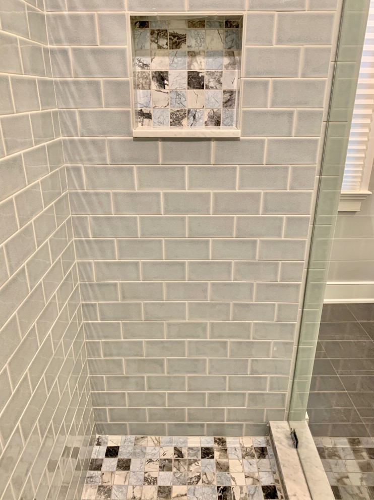 This is an example of an eclectic 3/4 bathroom in Philadelphia with an alcove shower, blue tile, ceramic tile, limestone floors, black floor and a hinged shower door.