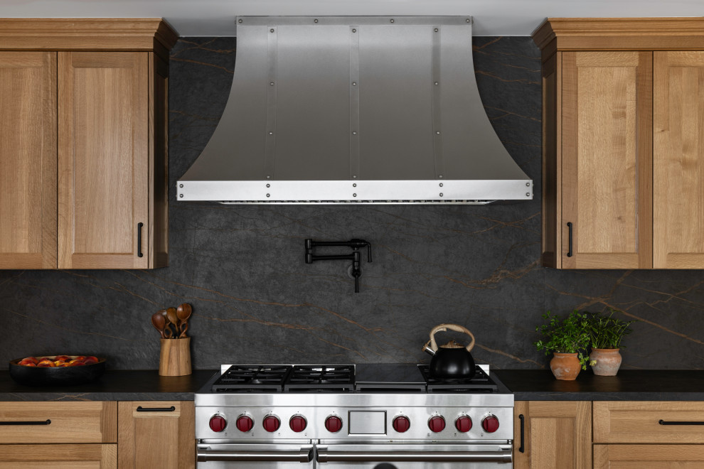 Large mountain style galley medium tone wood floor enclosed kitchen photo in DC Metro with an undermount sink, recessed-panel cabinets, medium tone wood cabinets, quartz countertops, black backsplash, quartz backsplash, stainless steel appliances, no island and black countertops