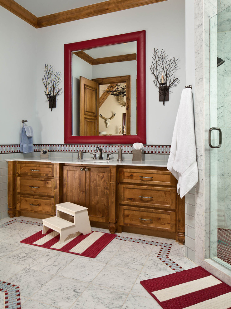 Design ideas for a traditional bathroom in Dallas with shaker cabinets, medium wood cabinets, gray tile and subway tile.