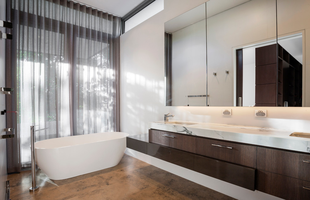Design ideas for a large contemporary master bathroom in Perth with an undermount sink, dark wood cabinets, marble benchtops, a freestanding tub, an open shower, a wall-mount toilet, white tile, ceramic tile, white walls and limestone floors.