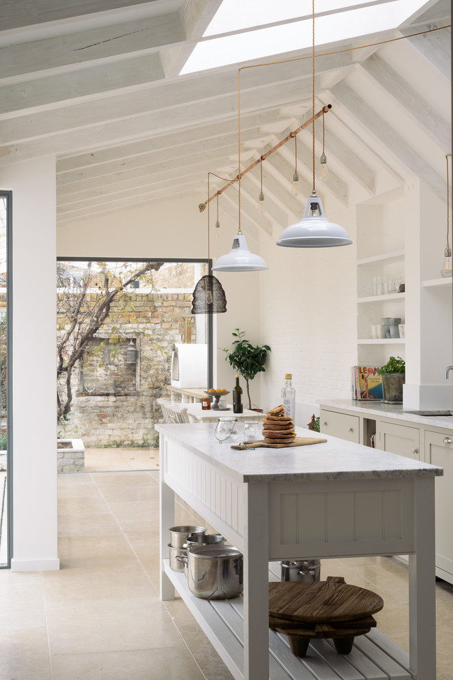 Photo of a mid-sized transitional single-wall eat-in kitchen in Other with shaker cabinets, grey cabinets, quartzite benchtops, white splashback, ceramic splashback, white appliances, limestone floors, with island, beige floor, white benchtop and an undermount sink.