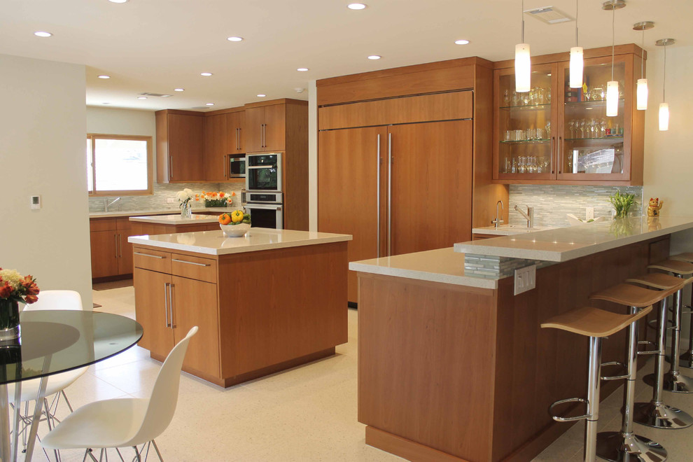 Inspiration for an expansive midcentury open plan kitchen in Los Angeles with an undermount sink, flat-panel cabinets, medium wood cabinets, quartz benchtops, multi-coloured splashback, glass tile splashback, stainless steel appliances and multiple islands.