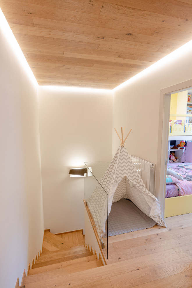 This is an example of a small scandinavian hallway in Milan with brown walls, medium hardwood floors, grey floor, recessed and wood walls.