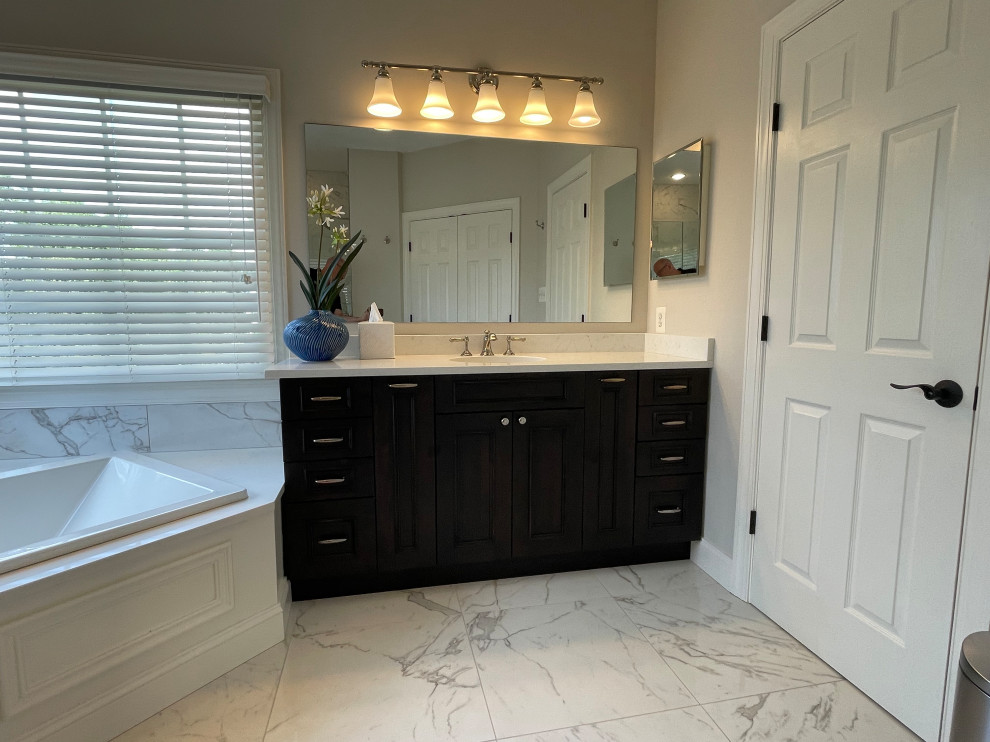 Drop-in bathtub - large master white tile and porcelain tile ceramic tile, brown floor and single-sink drop-in bathtub idea in DC Metro with recessed-panel cabinets, black cabinets, a two-piece toilet, an undermount sink, quartz countertops, a hinged shower door, white countertops, a niche and a built-in vanity