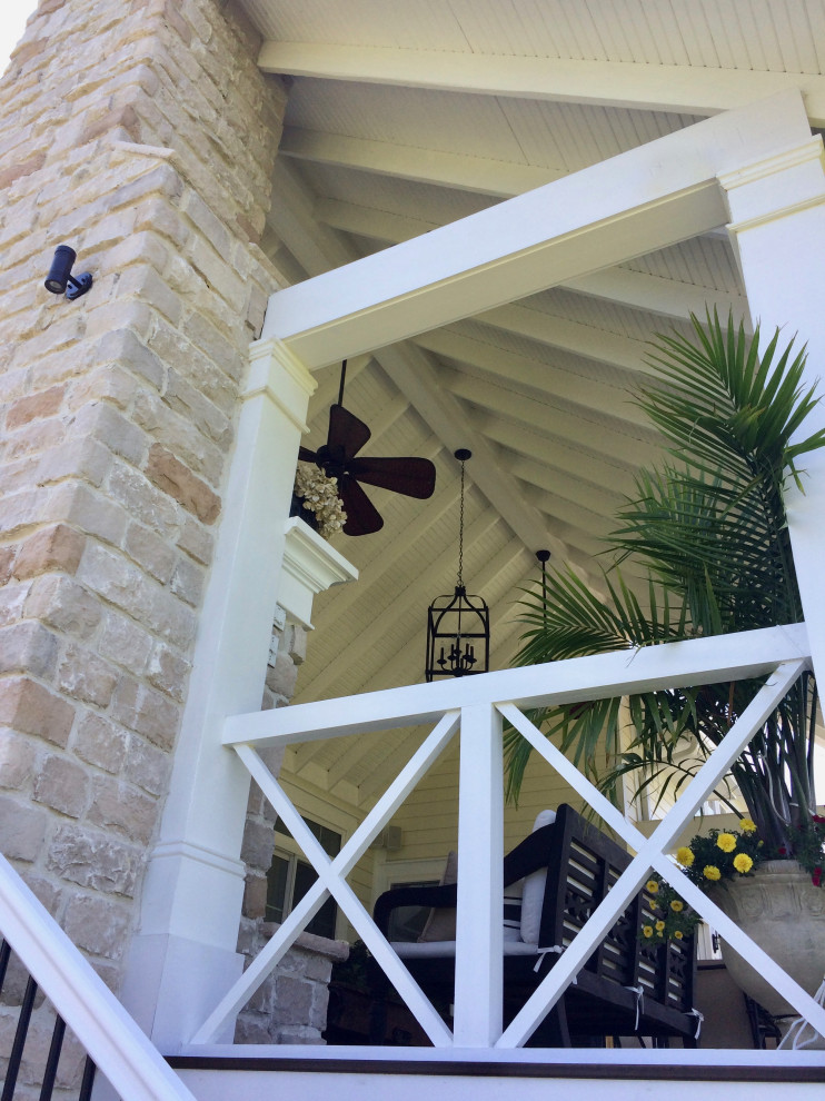 Imagen de terraza columna tradicional renovada de tamaño medio en patio trasero y anexo de casas con columnas, entablado y barandilla de varios materiales