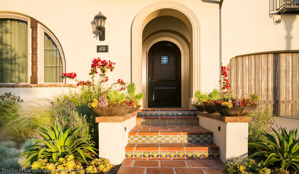 Photo of a mid-sized mediterranean entryway in Orange County with a single front door and a black front door.