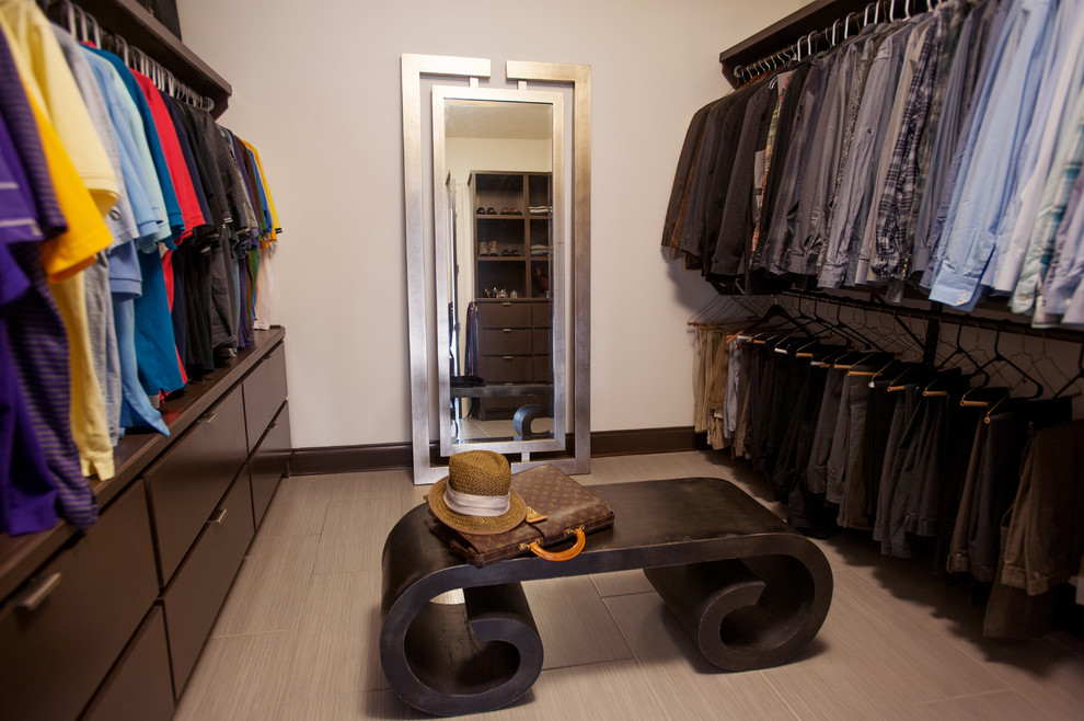 This is an example of a contemporary dressing room in New Orleans with dark wood cabinets and ceramic floors.