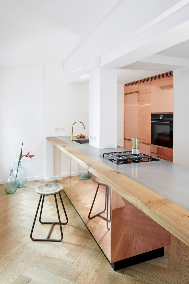 Offene, Mittelgroße Moderne Küche mit integriertem Waschbecken, Betonarbeitsplatte, braunem Holzboden, Kücheninsel, braunem Boden und grauer Arbeitsplatte in Berlin