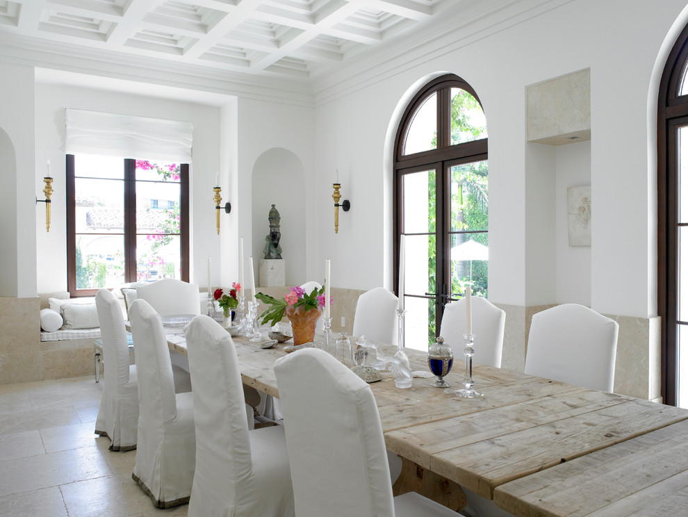 This is an example of a country dining room in Miami with white walls.