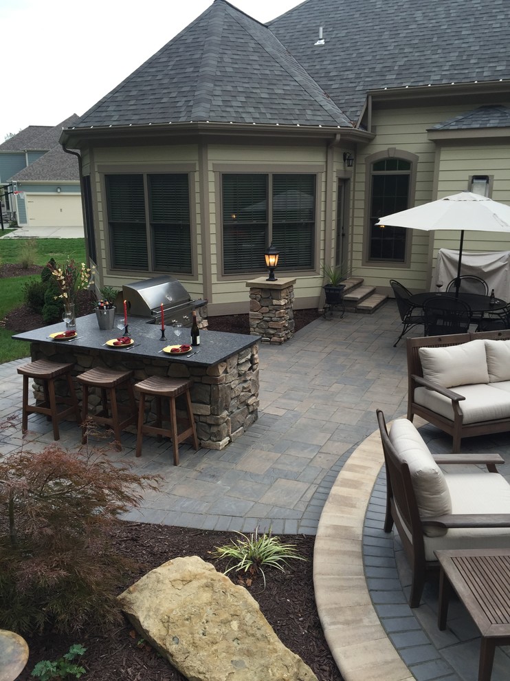 Design ideas for a large traditional backyard patio in Other with concrete pavers and no cover.