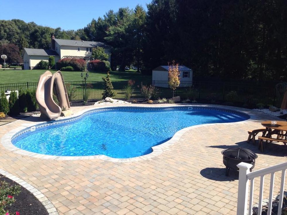 Hot tub - large backyard custom-shaped natural hot tub idea in New York
