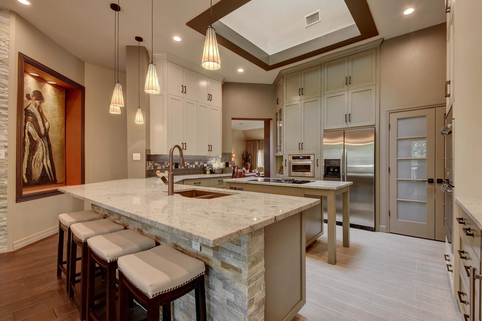 Inspiration for a mid-sized u-shaped separate kitchen in Austin with a double-bowl sink, shaker cabinets, beige cabinets, granite benchtops, multi-coloured splashback, stainless steel appliances, porcelain floors, multiple islands, grey floor and beige benchtop.