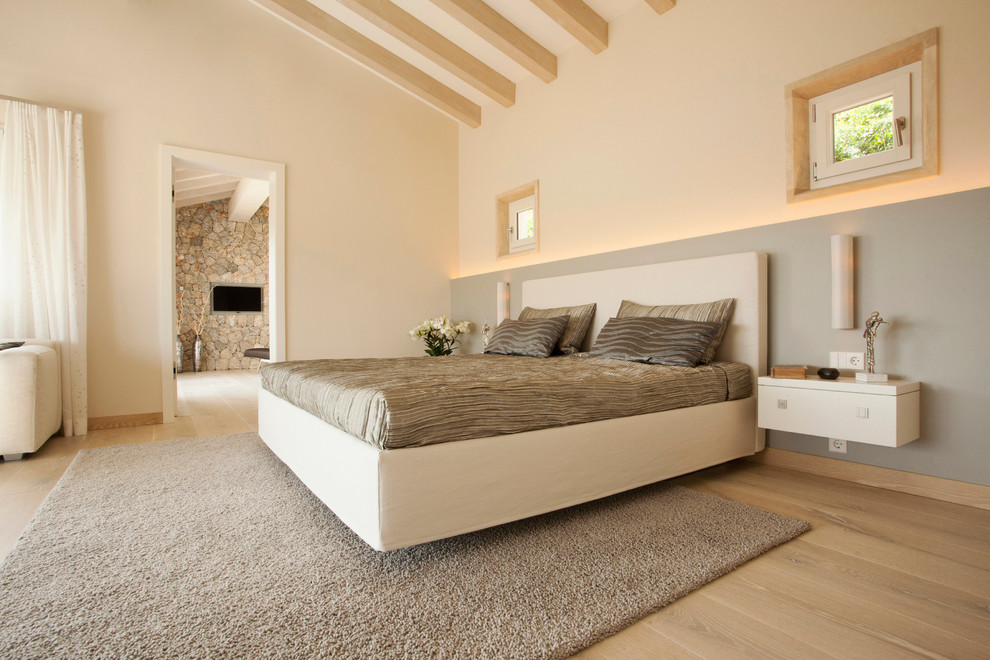 Inspiration for a mid-sized contemporary master bedroom in Munich with beige walls, light hardwood floors and no fireplace.