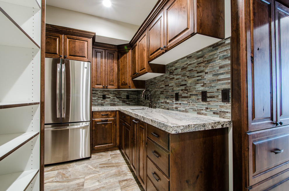 Photo of a large arts and crafts u-shaped kitchen pantry in Salt Lake City with an undermount sink, raised-panel cabinets, medium wood cabinets, granite benchtops, multi-coloured splashback, matchstick tile splashback, stainless steel appliances and ceramic floors.