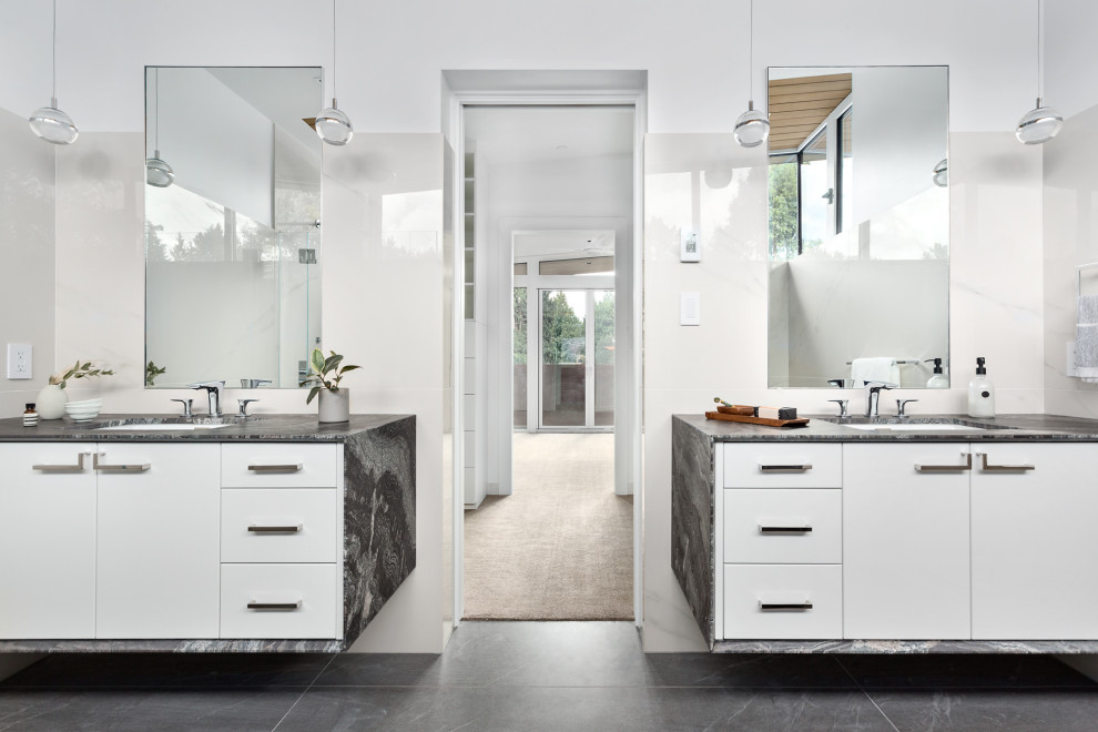 Photo of a large contemporary master bathroom in Vancouver with white cabinets, a drop-in tub, an alcove shower, white tile, ceramic tile, ceramic floors, a drop-in sink, quartzite benchtops, grey floor, a hinged shower door and black benchtops.