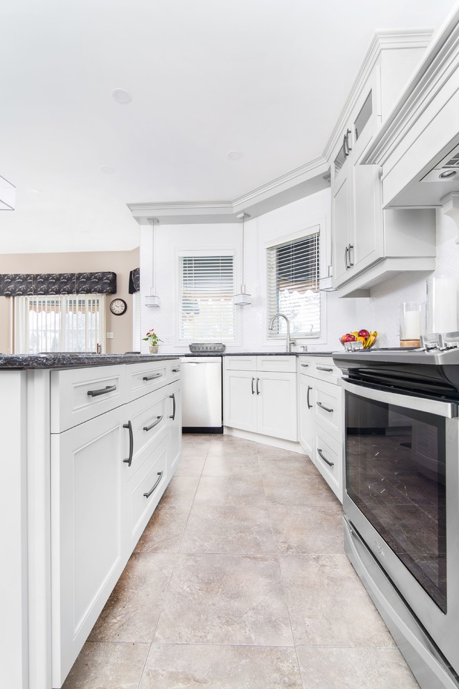Example of a large transitional u-shaped ceramic tile and beige floor enclosed kitchen design with a double-bowl sink, recessed-panel cabinets, gray cabinets, granite countertops, stainless steel appliances, an island and black countertops
