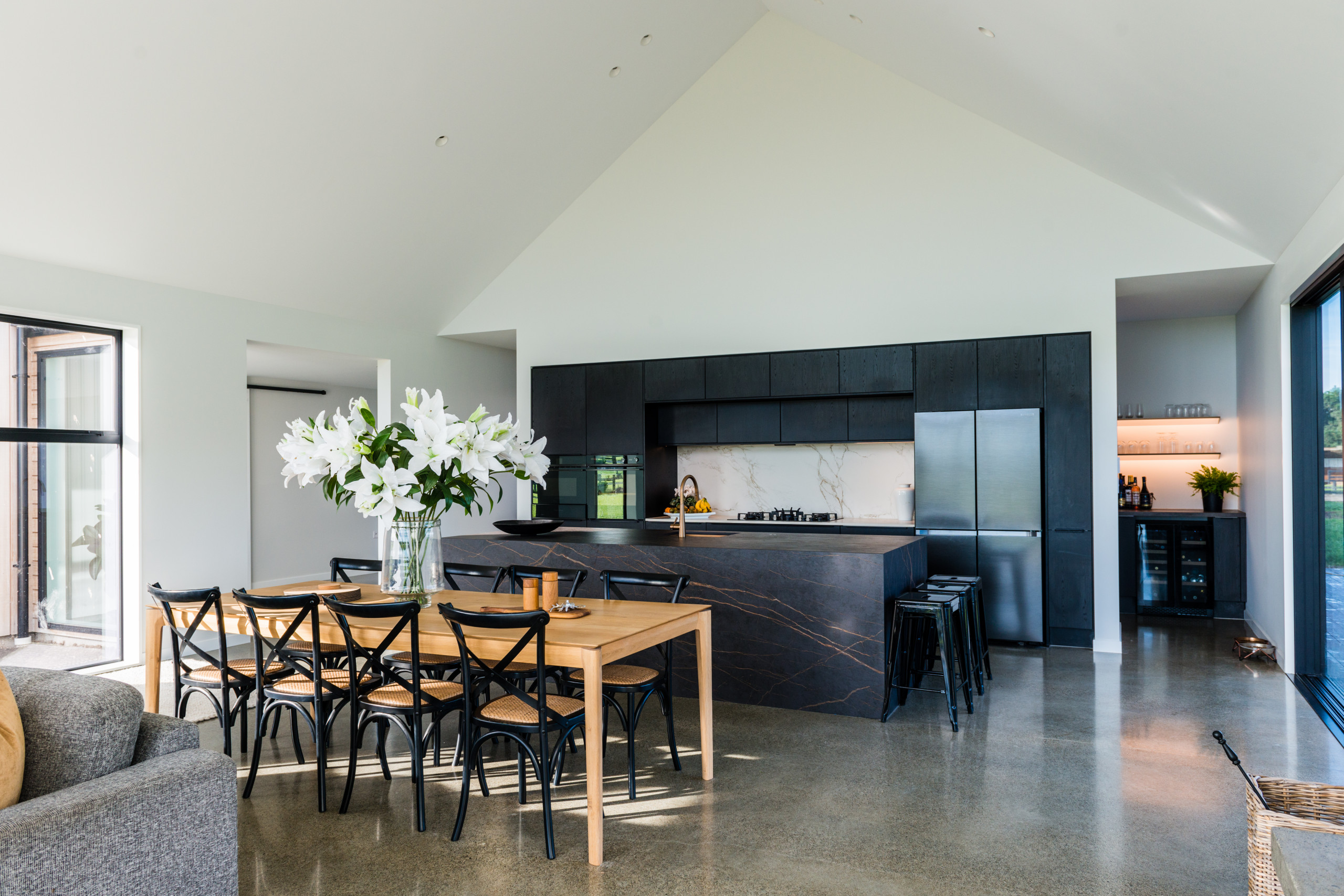 Inspiration for a contemporary concrete floor and vaulted ceiling kitchen/dining room combo remodel in Christchurch with white walls