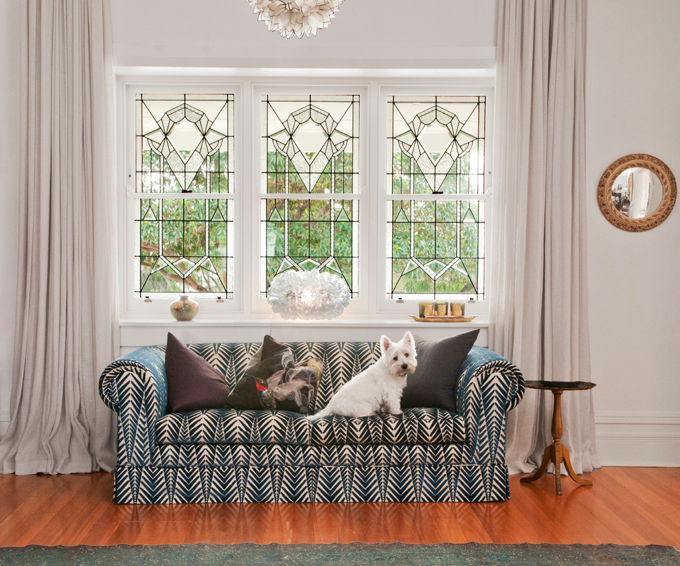 This is an example of a mid-sized eclectic open concept living room in Perth with white walls and medium hardwood floors.