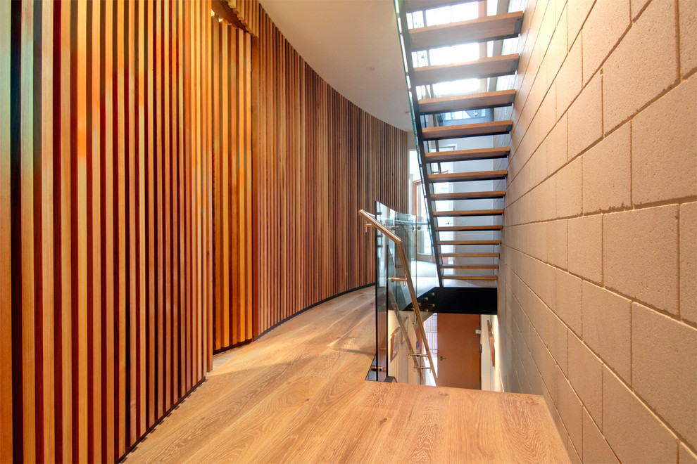Design ideas for a mid-sized contemporary wood straight staircase in Other with open risers and glass railing.