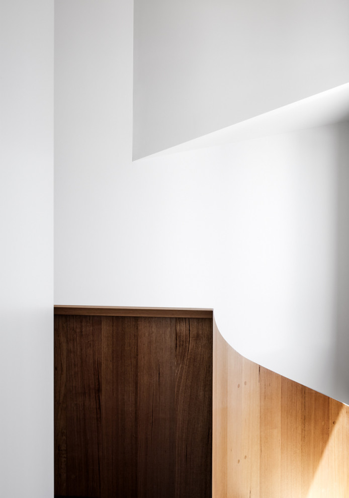 На фото: большая винтовая деревянная лестница в современном стиле с деревянными ступенями и деревянными стенами с