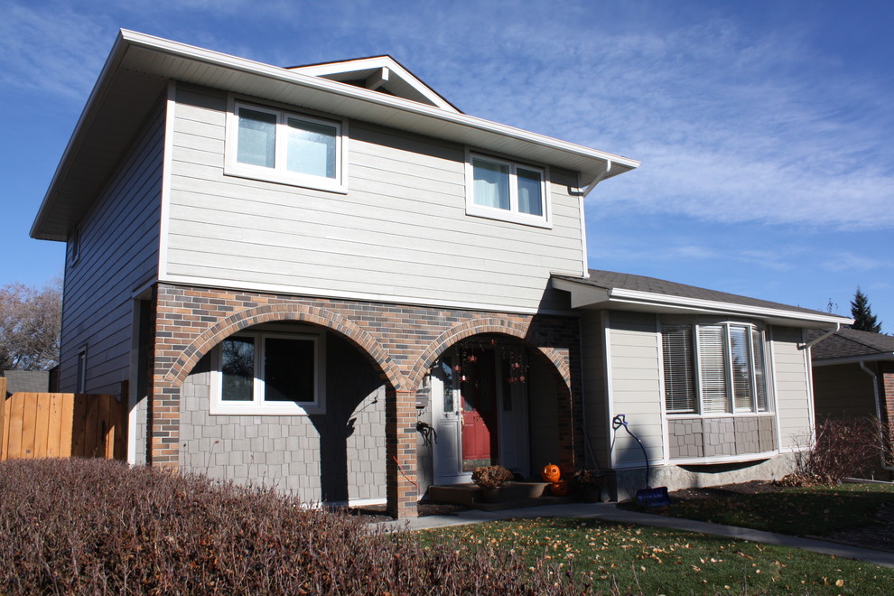 This is an example of a mid-sized traditional two-storey exterior in Calgary with concrete fiberboard siding.