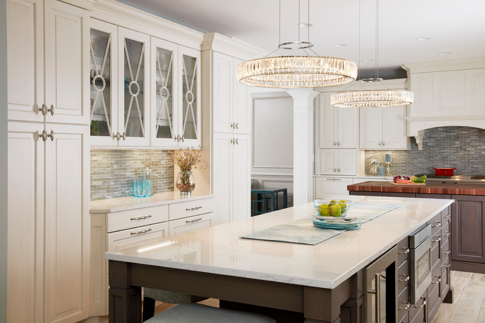 Expansive traditional u-shaped open plan kitchen in Baltimore with a farmhouse sink, raised-panel cabinets, white cabinets, quartz benchtops, blue splashback, mosaic tile splashback, stainless steel appliances, porcelain floors, multiple islands, grey floor and white benchtop.