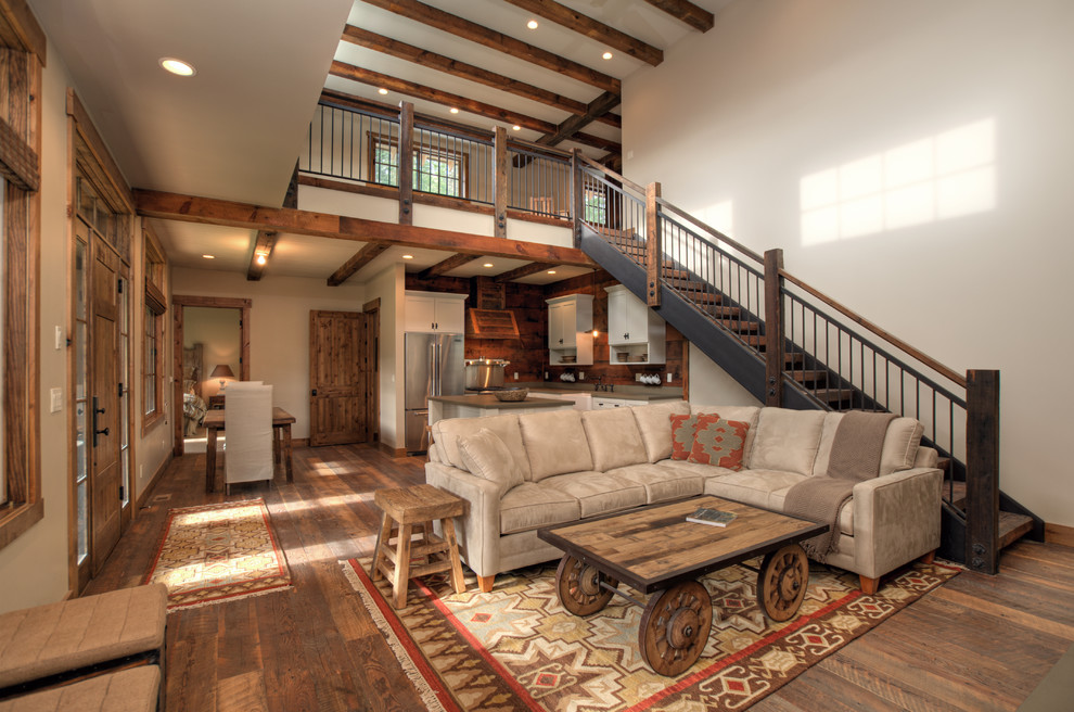 Photo of a large traditional loft-style living room in Seattle with beige walls, dark hardwood floors and no fireplace.
