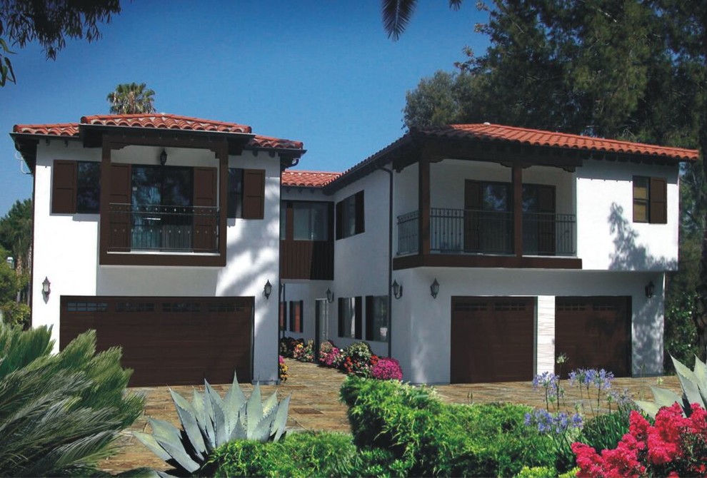 This is an example of a large traditional two-storey stucco white house exterior in Los Angeles with a gable roof and a shingle roof.