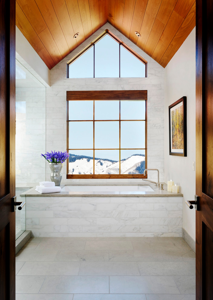 Inspiration for a transitional master bathroom in Denver with an undermount tub, a two-piece toilet, white tile, stone tile, white walls, limestone floors, an undermount sink and granite benchtops.