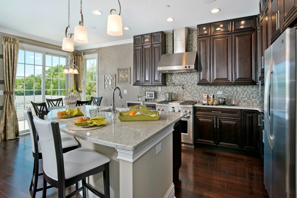 Open concept kitchen - large transitional l-shaped dark wood floor open concept kitchen idea in Chicago with an undermount sink, raised-panel cabinets, dark wood cabinets, quartz countertops, multicolored backsplash, mosaic tile backsplash, stainless steel appliances and an island
