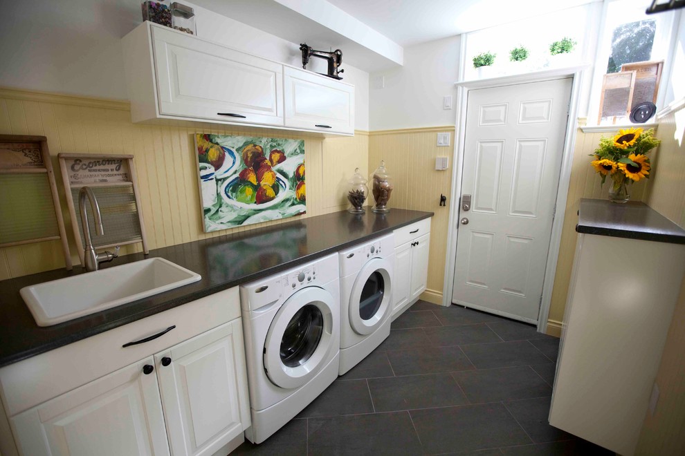 Small traditional galley utility room in Vancouver with a drop-in sink, raised-panel cabinets, white cabinets, laminate benchtops, yellow walls, porcelain floors and a side-by-side washer and dryer.