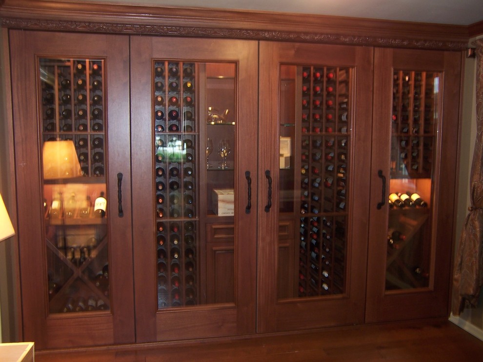 This is an example of a mid-sized traditional wine cellar in Philadelphia with light hardwood floors, diamond bins and brown floor.